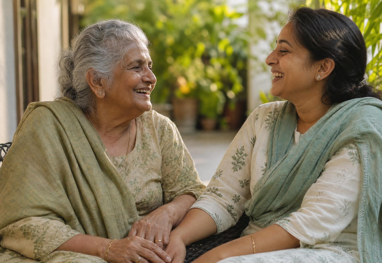 An older mother and her adult daughter laughing together on a veranda